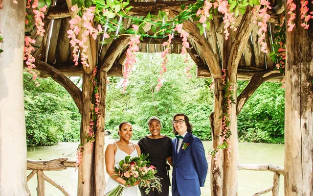 A couple standing together beneath a ceremony arch