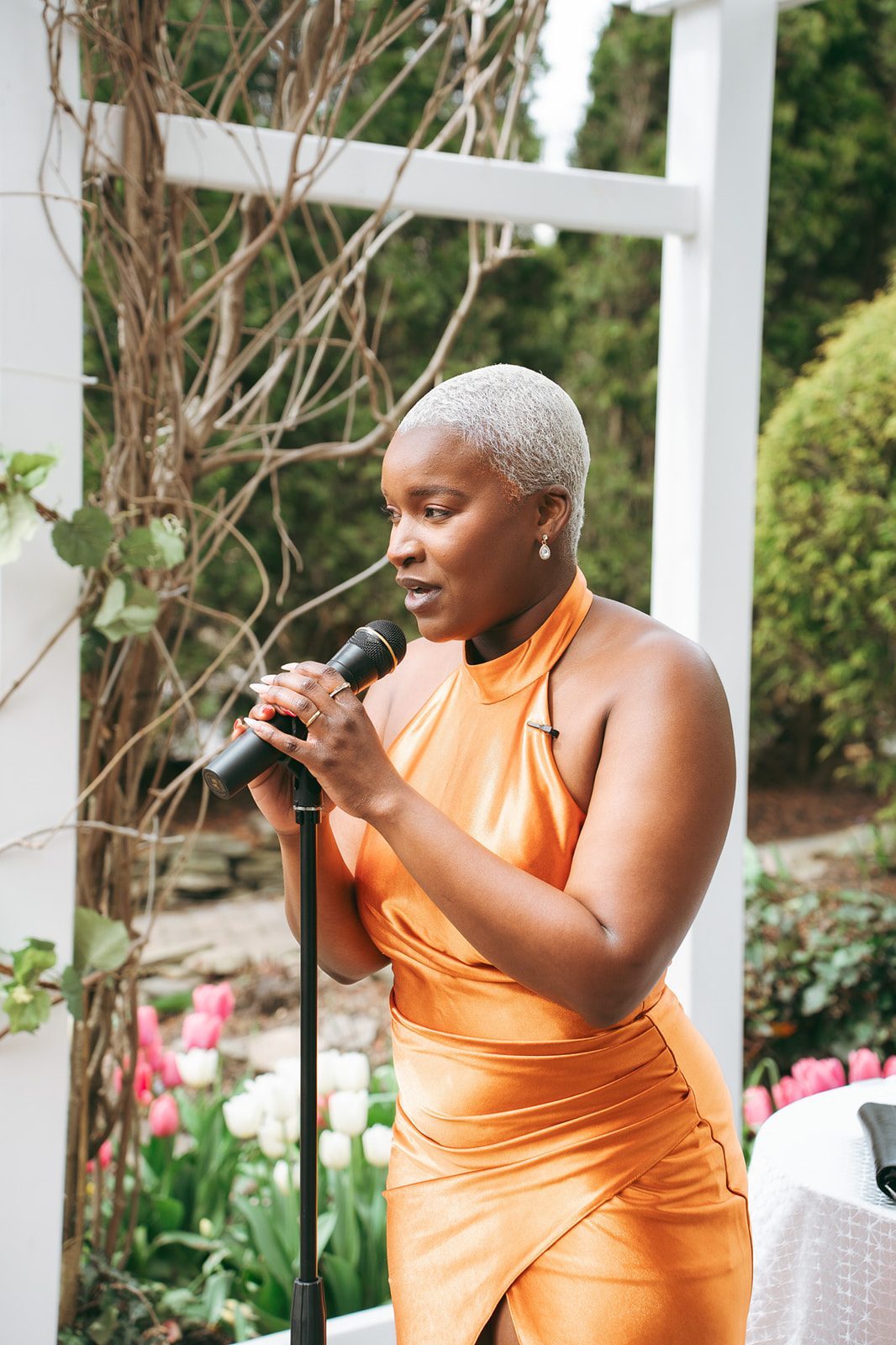 Robyn Walker officiating at a garden altar, microphone in hand