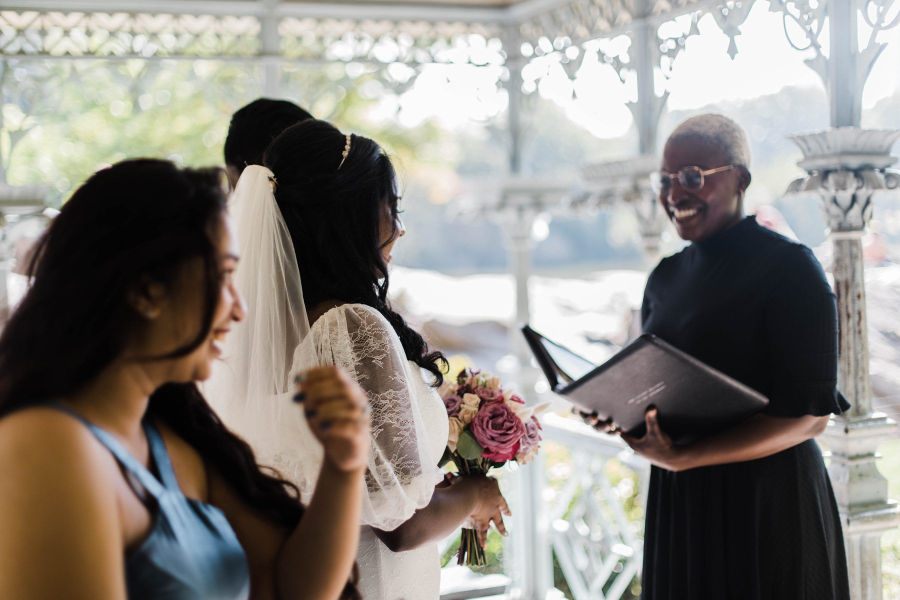 Robyn reading from her ceremony book for two brides at the Ladies' Pavilion in Central Park