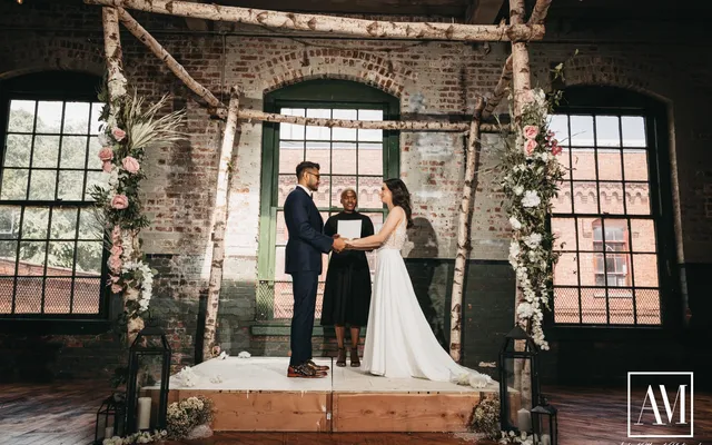 A couple exchanging vows in a simple ceremony arch setting