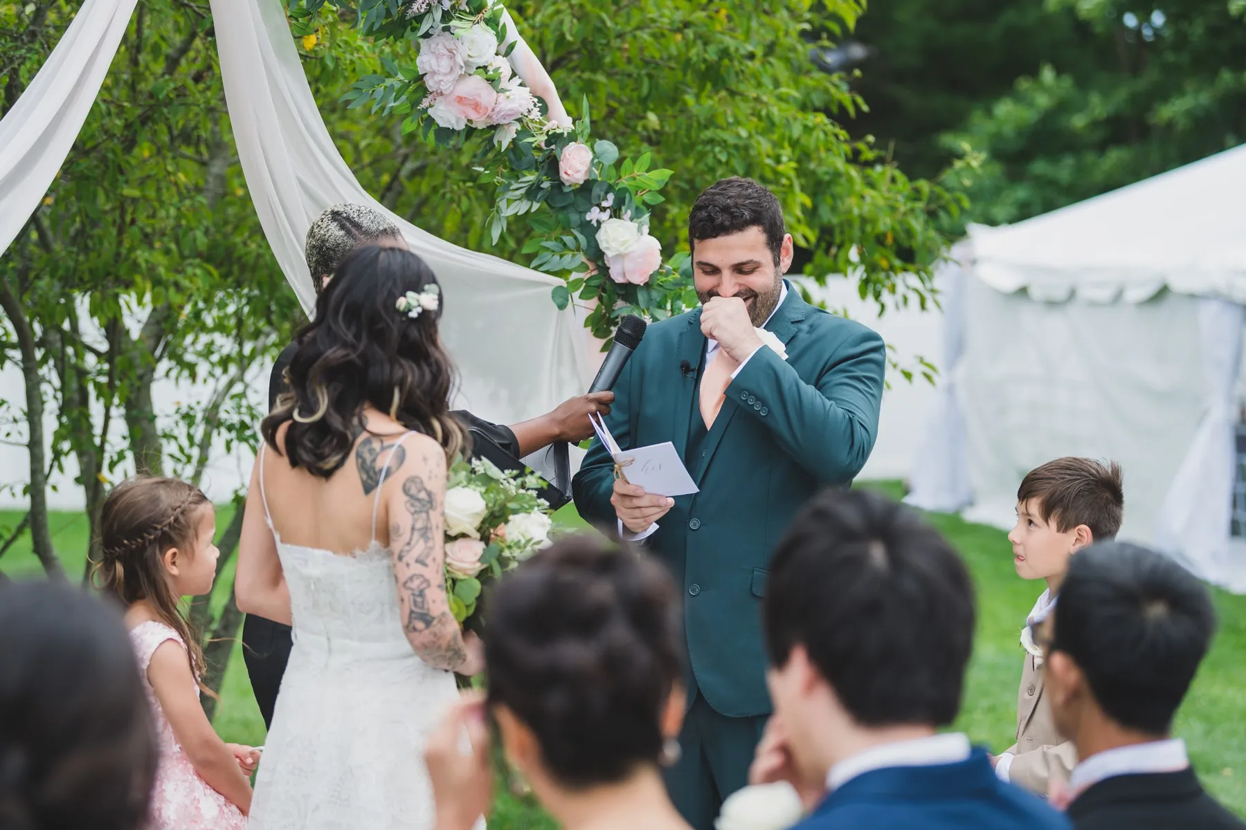 Robyn Walker with a couple at their floral ceremony arch