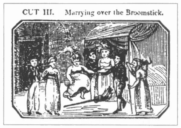 An 1822 woodcut print titled 'Marrying over the Broomstick,' showing a couple in early-19th-century dress jumping a broom inside a cottage while onlookers watch from both sides