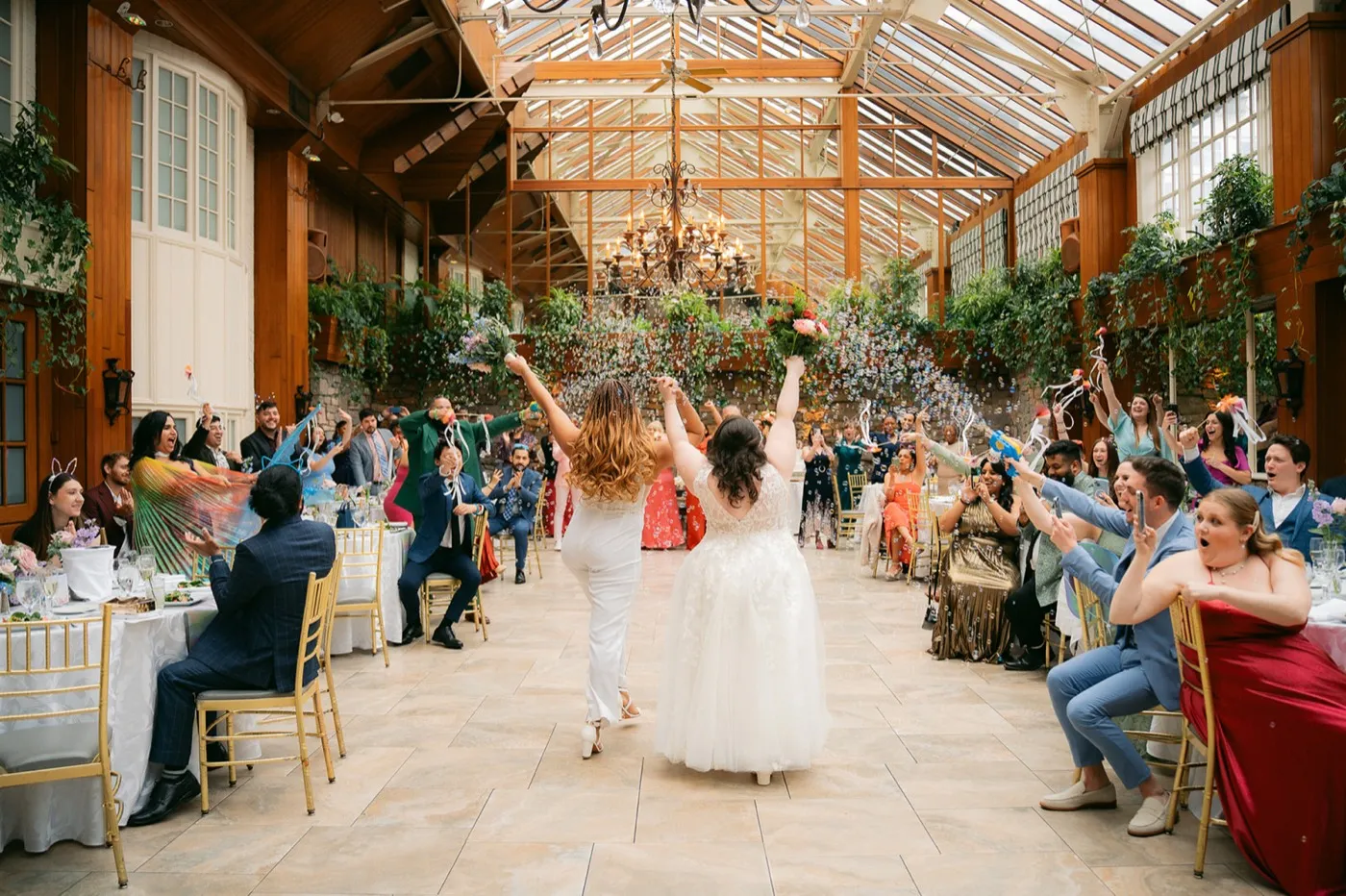 A huge group celebration of newlyweds, family raising hands in joy