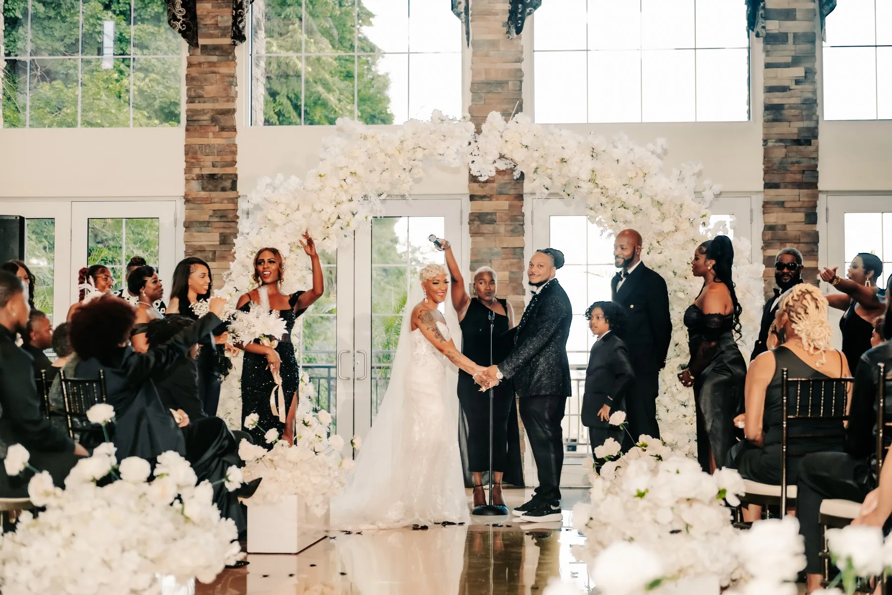 The full wedding party celebrating with the couple after the ceremony