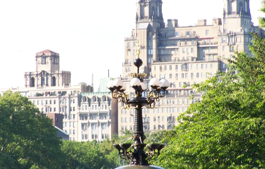 The ornate cast-metal top of the Cherry Hill fountain with its round glass lamps, the San Remo apartment towers rising behind it